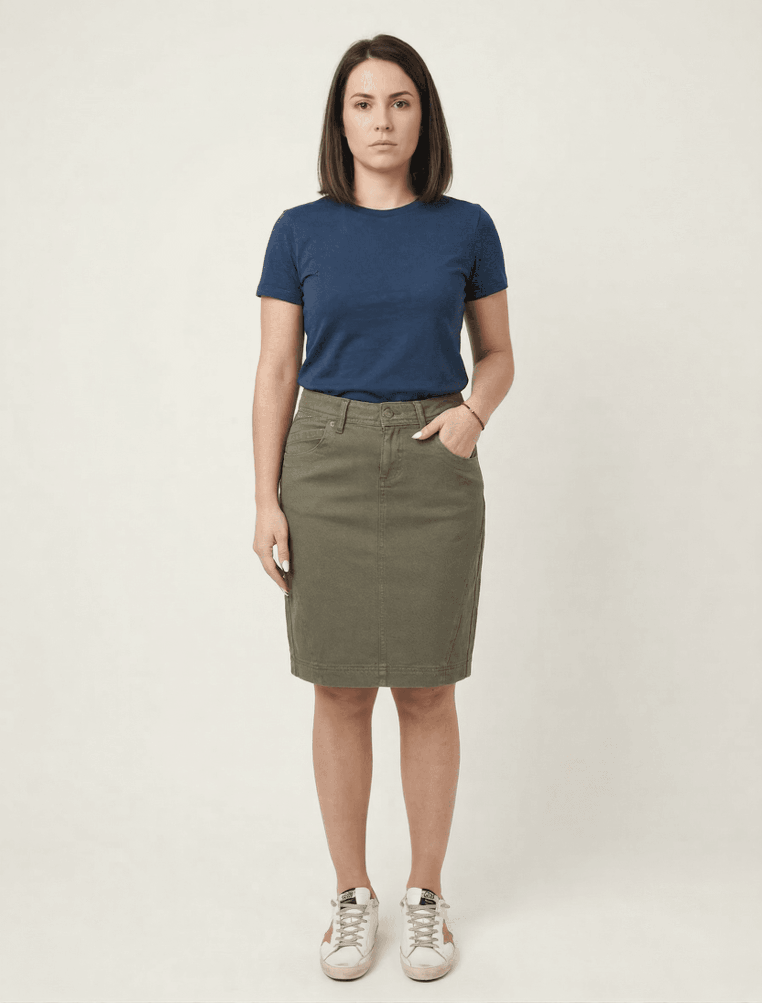 Žena nosi maslinastu suknju dužine 50cm. Elegantna i moderna, idealna za žene.