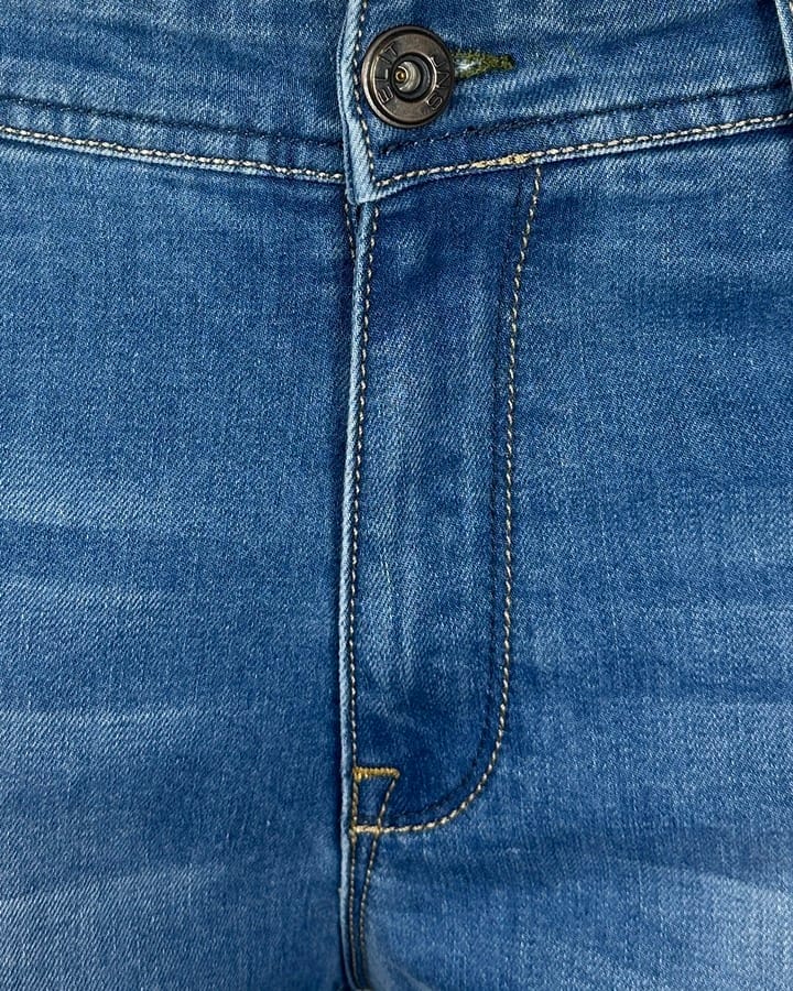 Krupni plan materijala i štepa na svetlo plavim Elit farmerkama