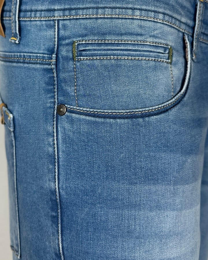 Krupni plan materijala i štepa na svetlo plavim Elit farmerkama