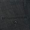Detalj kariranih muških pantalona slim fit sa džepom i dugmetom.