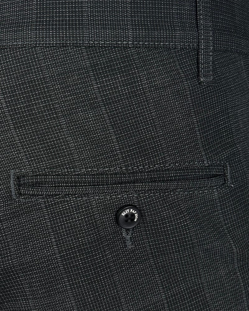 Detalj kariranih muških pantalona slim fit sa džepom i dugmetom. Detalj kariranih muških pantalona slim fit sa džepom i dugmetom.