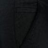 Detalj elegantnih muških pantalona sa teksturom, regular fit kroja, crne boje. Tekstura tkanine se jasno vidi.