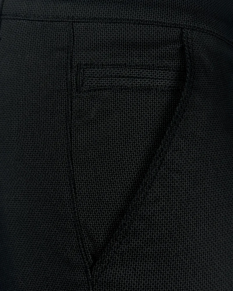 Detalj elegantnih muških pantalona sa teksturom, regular fit kroja, crne boje. Tekstura tkanine se jasno vidi. Detalj elegantnih muških pantalona sa teksturom, regular fit kroja, crne boje. Tekstura tkanine se jasno vidi.