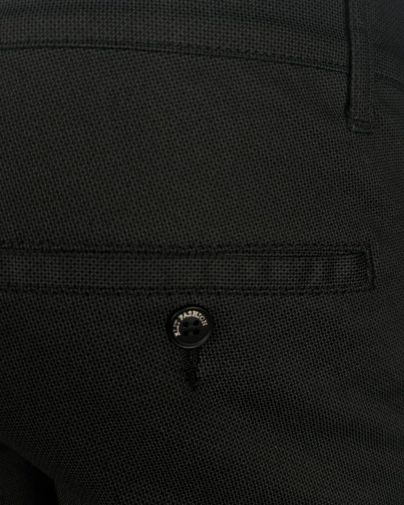 Detalj elegantnih muških pantalona sa teksturom, regular fit kroja. Crne pantalone sa džepom i dugmetom. Detalj elegantnih muških pantalona sa teksturom, regular fit kroja. Crne pantalone sa džepom i dugmetom.
