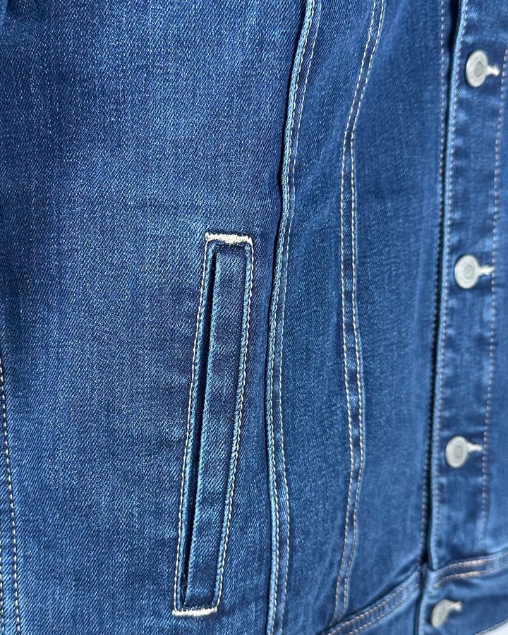 Detalj teksas jakne, džep i dugmad.