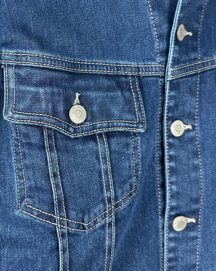 Detalj džins jakne sa džepom i dugmićima.