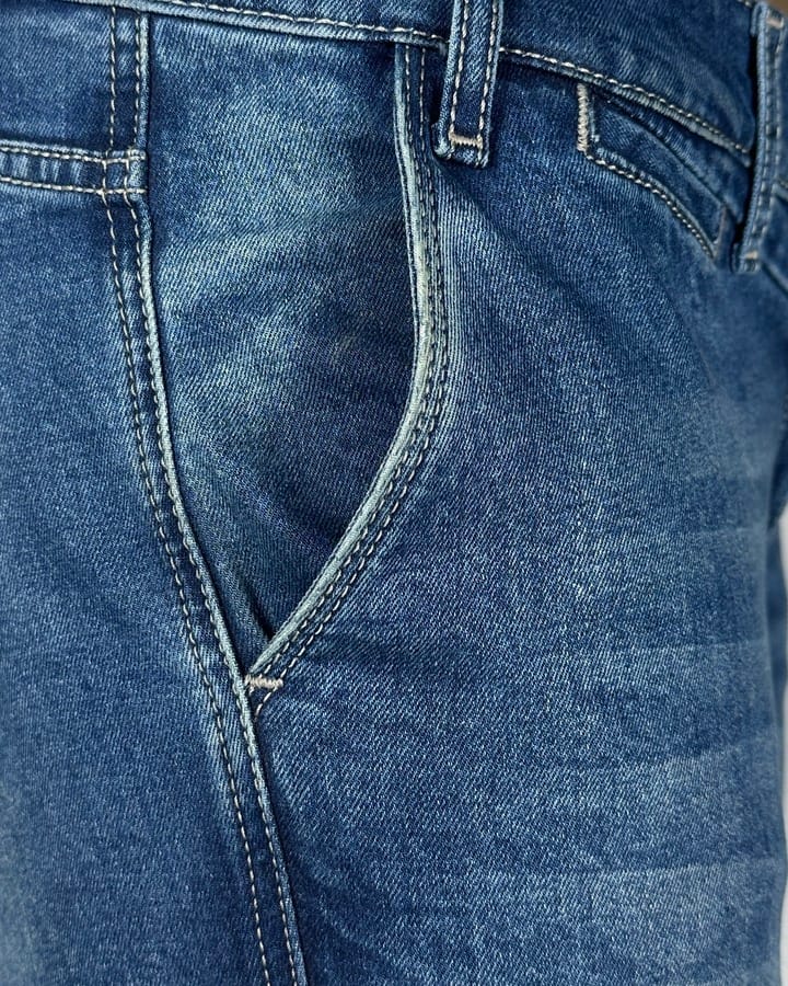 Detaljan prikaz džepa elegantnih muških termo pantalona za zimu, plavi džins sa belim štepovima.