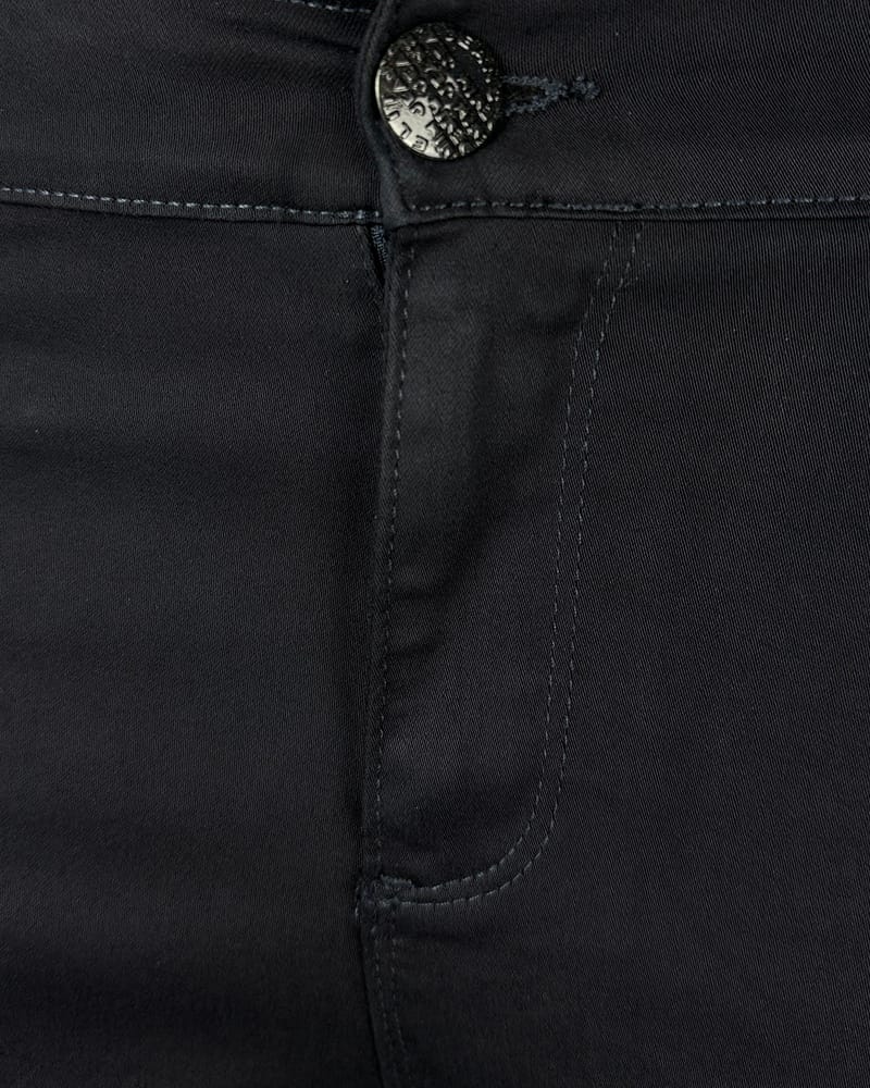 Teget ženske pantalone 7/8 - Detalj sa dugmetom Detaljan prikaz teget ženskih pantalona 7/8, klasičan stil sa diskretnim štepovima i dugmetom.