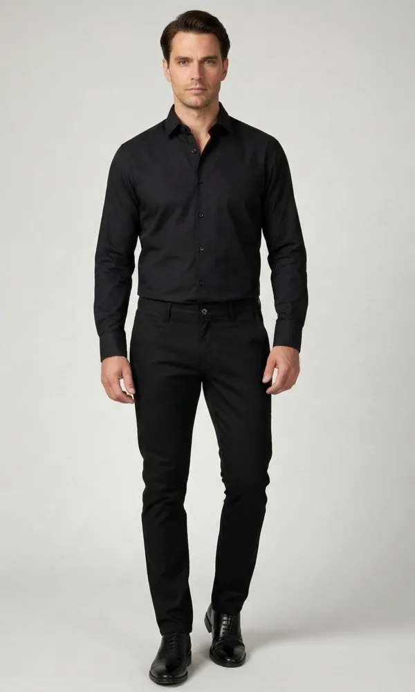 Crna muška košulja Muškarac nosi elegantnu crnu blago strukiranu košulju marke ELIT u kombinaciji sa crnim pantalonama.