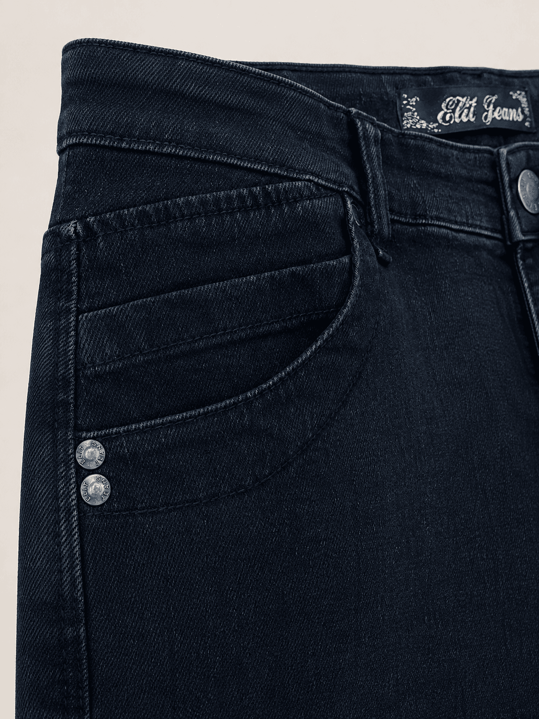 Detaljan prikaz tamne teksas suknje sa metalnim nitnama i Elit Jeans etiketom u predelu struka.